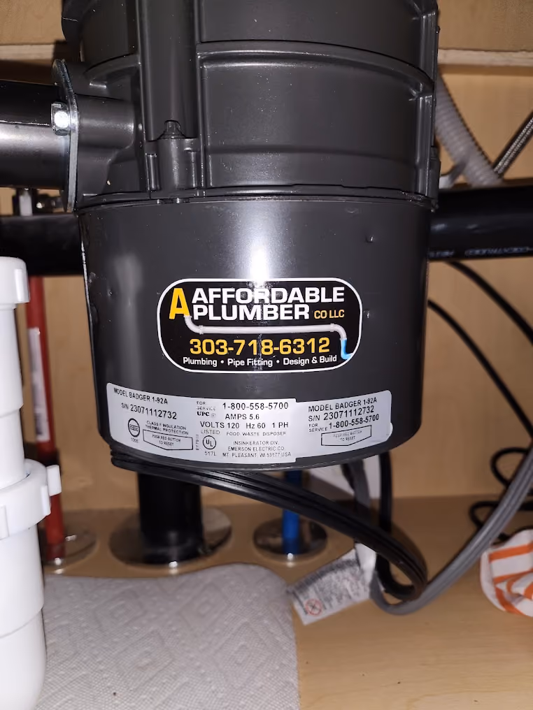 A garbage disposal with an Affordable Plumber sticker