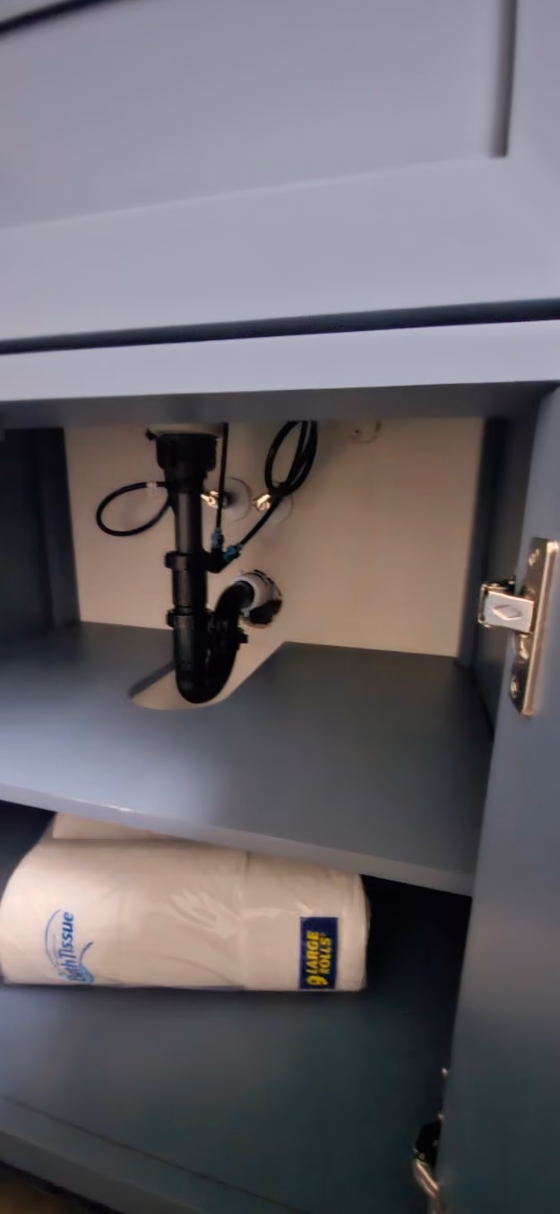 A new black drain trap under a vanity