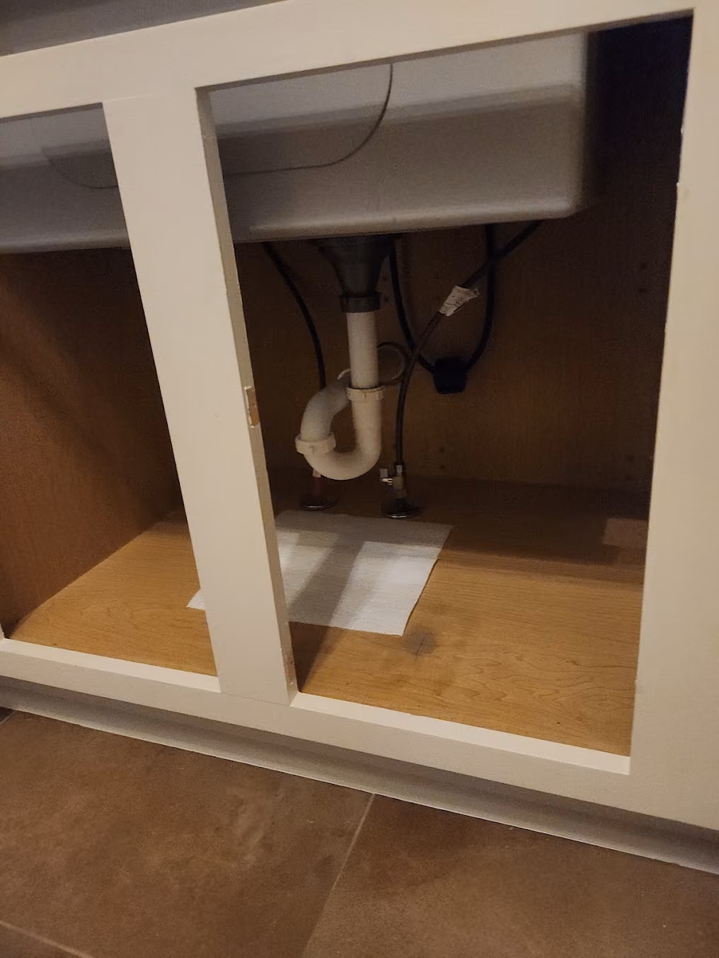 A new drain trap under a bathroom sink