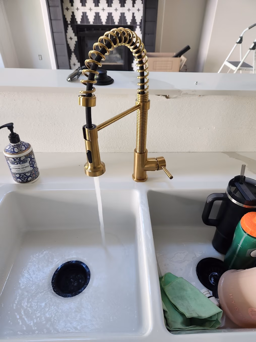 A brass pull-down faucet over a double sink