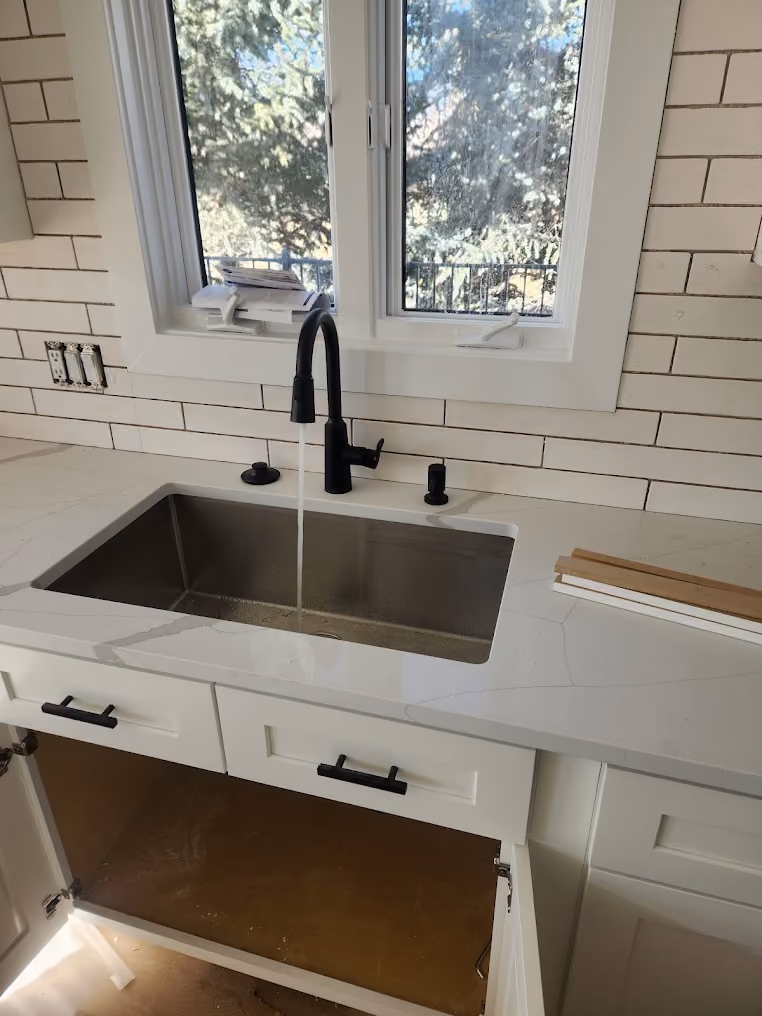 A matte black kitchen faucet over an undermount sink