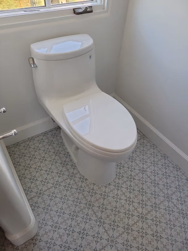 A new one-piece toilet on a patterned tile floor
