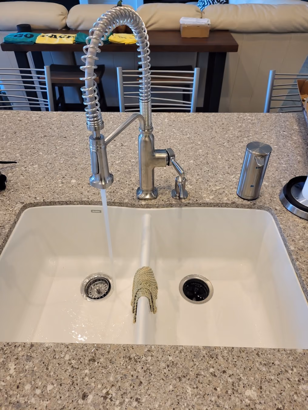 A pull-down kitchen faucet running into a white sink