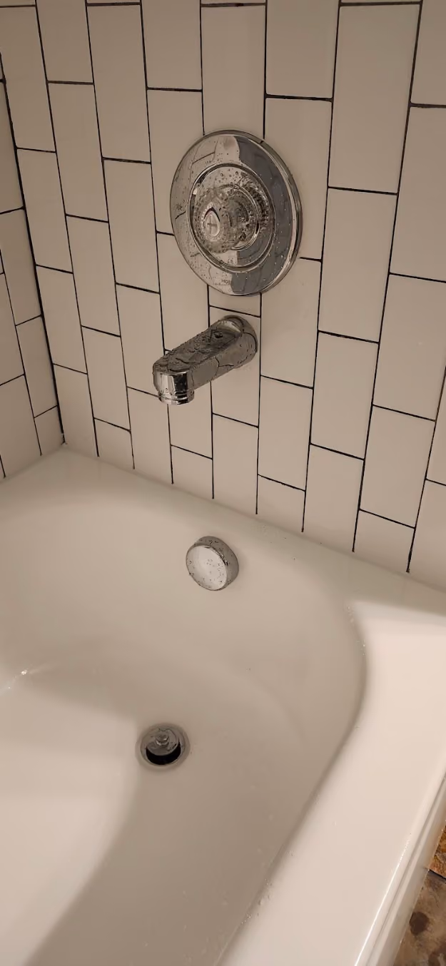 A new tub spout and drain in a tiled bathtub