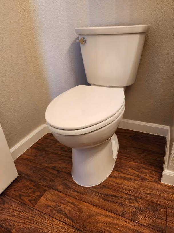 A new toilet on a wood floor