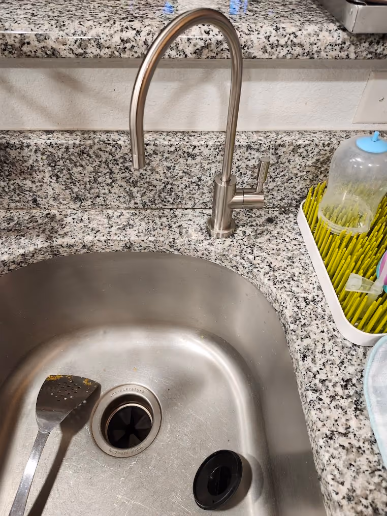 A pull-down faucet over a stainless sink