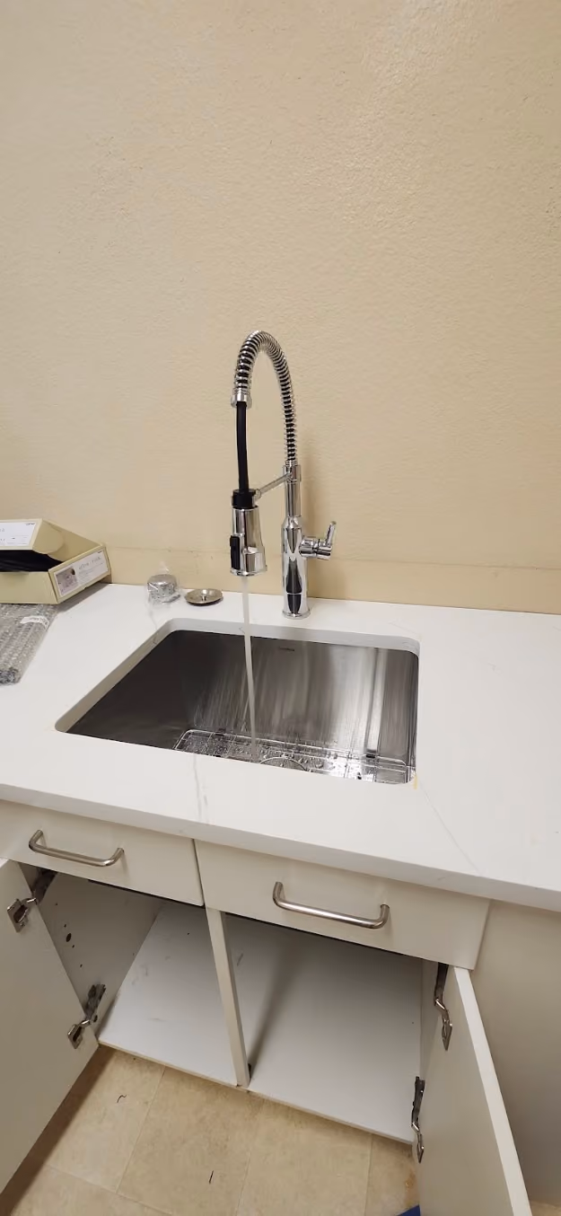 A spring pull-down faucet over a stainless sink