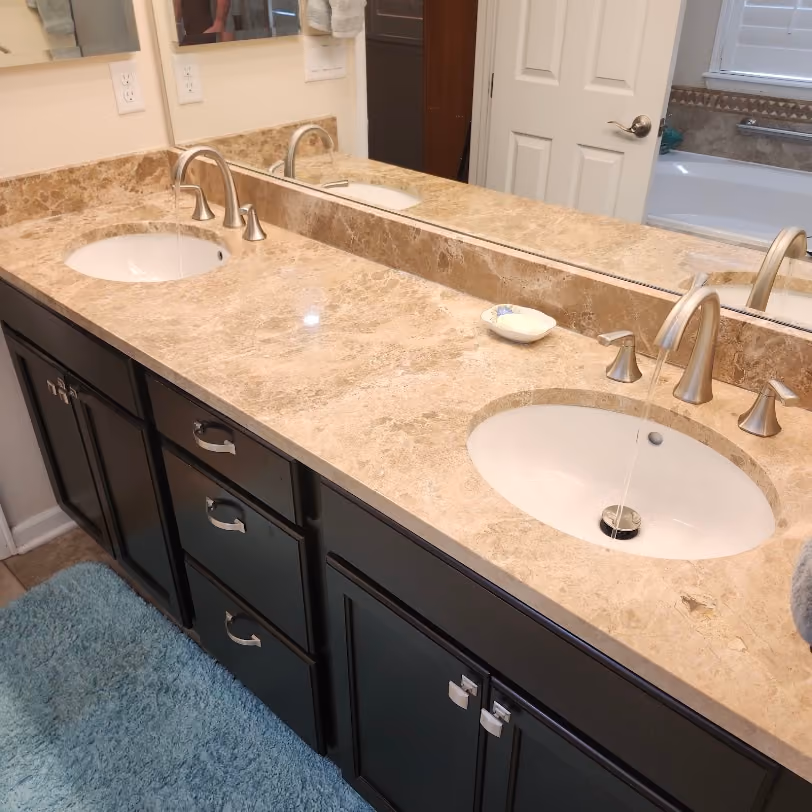 A double vanity with new faucets on a marble top