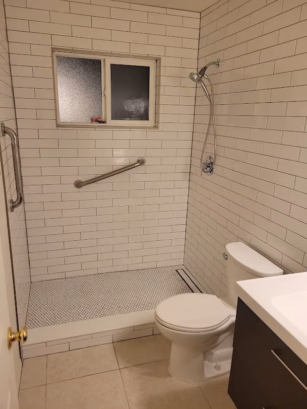 A remodeled bathroom with a tiled walk-in shower