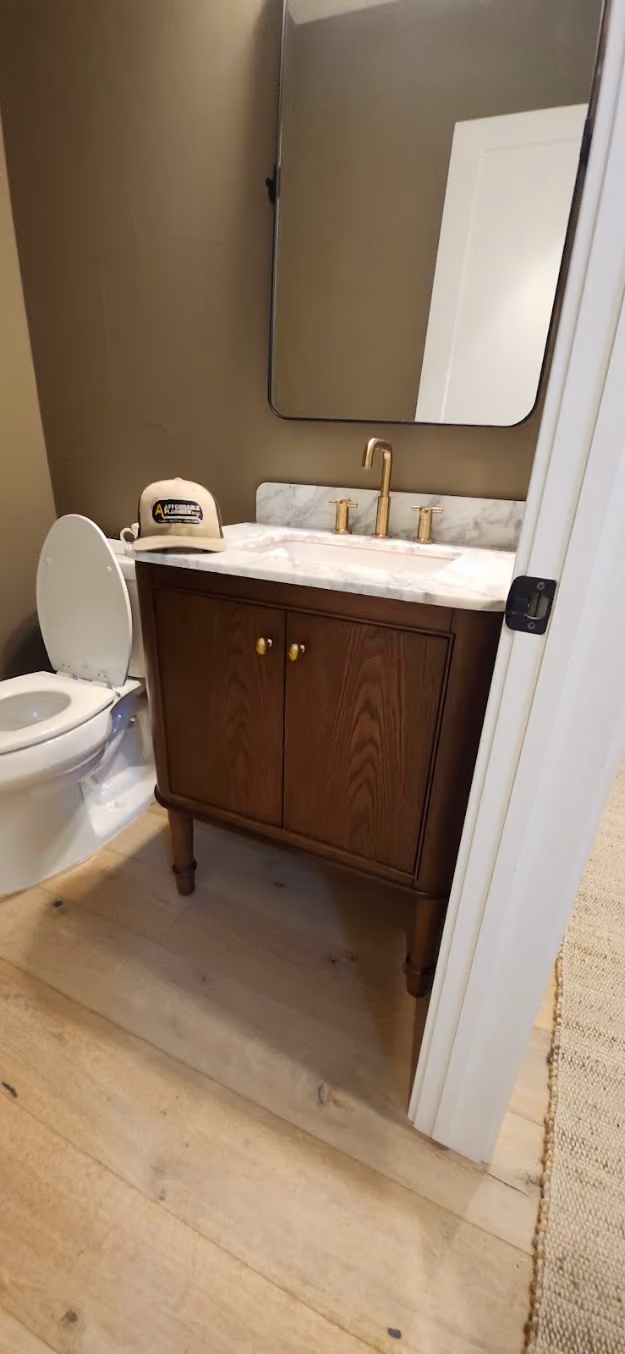 A wood vanity with a brass faucet