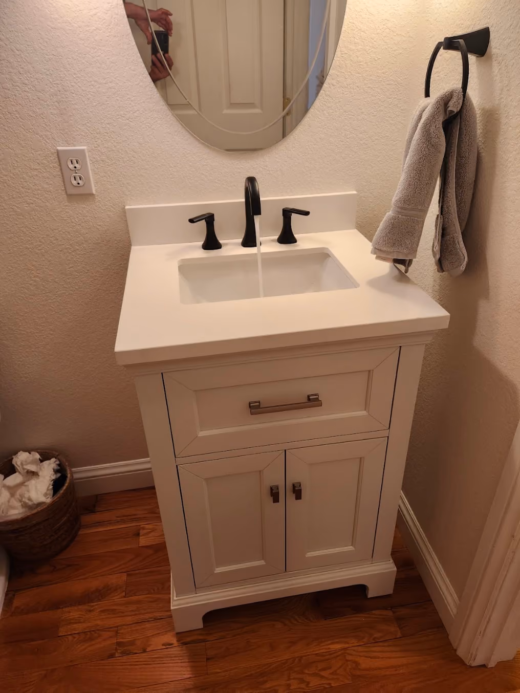 A new white vanity with a black faucet