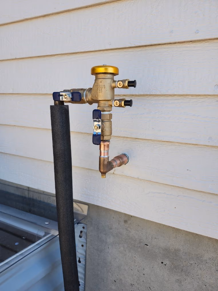 A new backflow preventer on the side of a house
