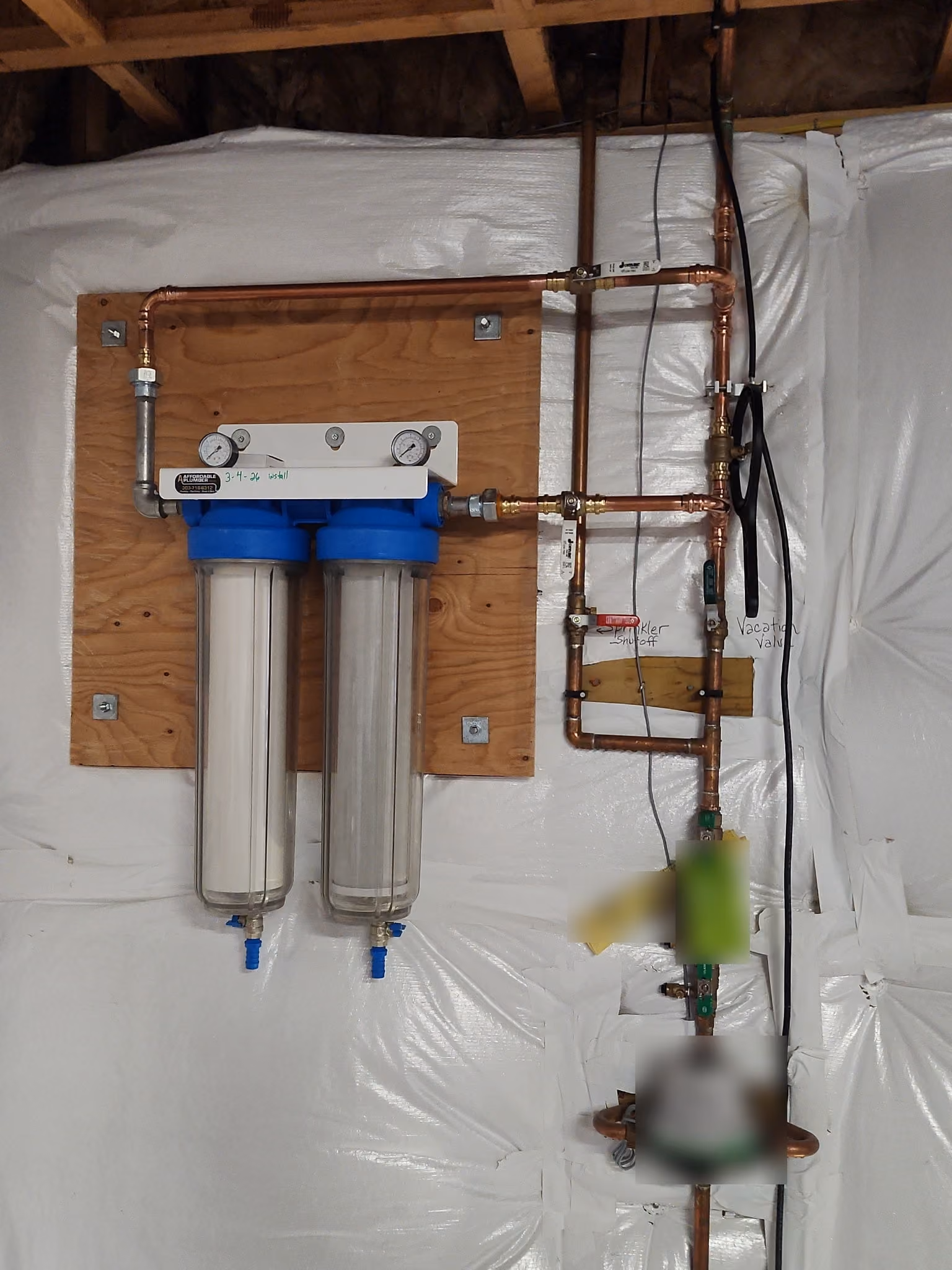 New copper water lines with a labeled sprinkler shut-off, a vacation valve and a whole-house water filter