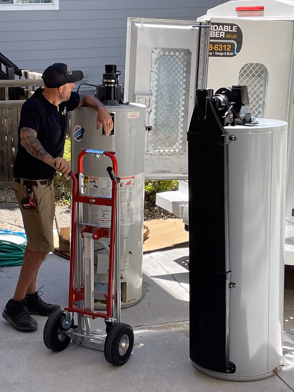Pat moving a new water heater into place on a hand truck