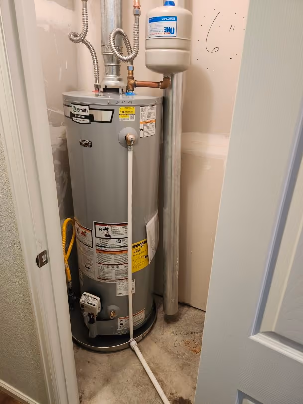 A gas water heater installed in a closet, with new supply lines