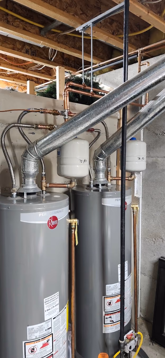 Two gas water heaters side by side, each with its own expansion tank