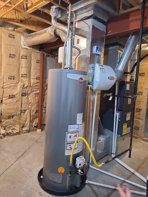 A new water heater with an expansion tank in an unfinished basement