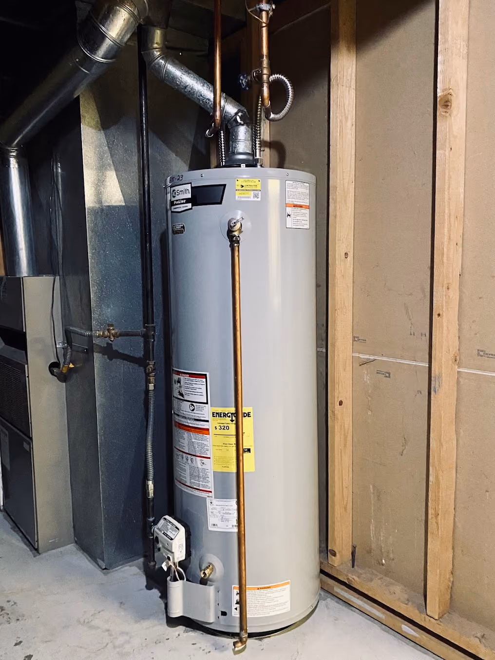 A gas water heater installed beside the furnace