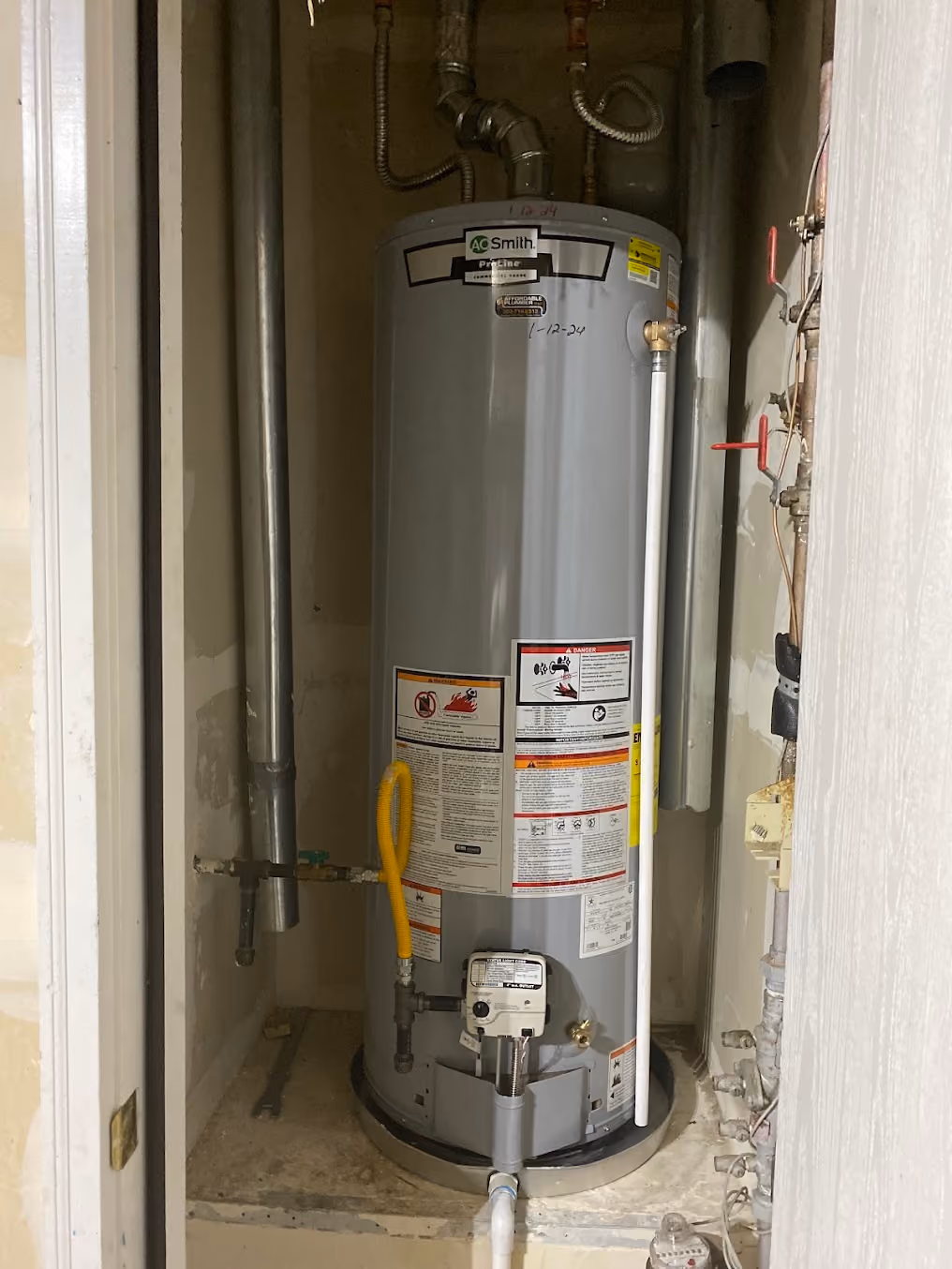 A water heater in a tight closet, with new copper and flexible lines