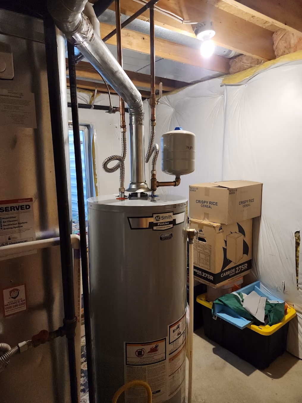 A water heater with an expansion tank in a basement storage room