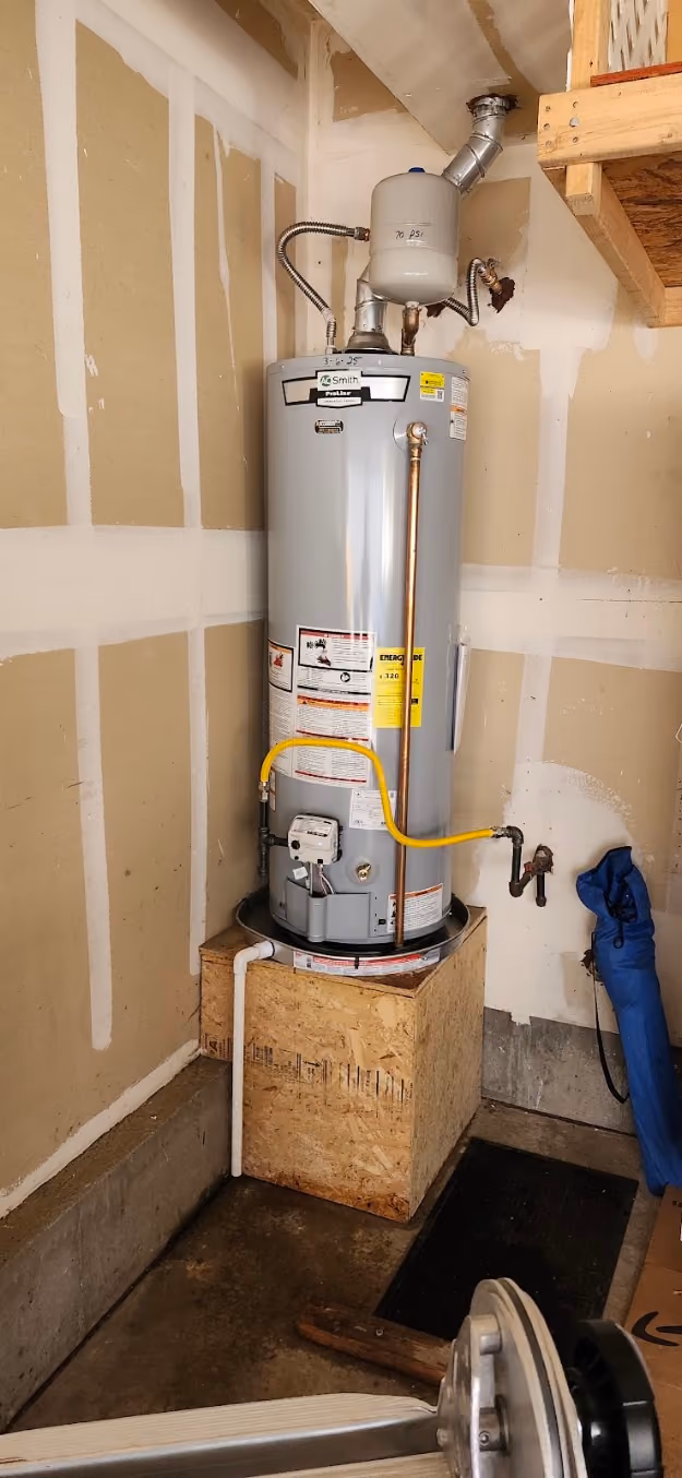 A water heater raised on a platform in a garage